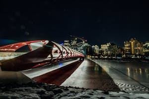 Visão noturna de um monumento com uma das melhores cidades para viver ao fundo, Calgary no Canadá.