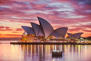 Por do sol ao fundo do Opera House, monumento famoso de Sydney, Austrália.