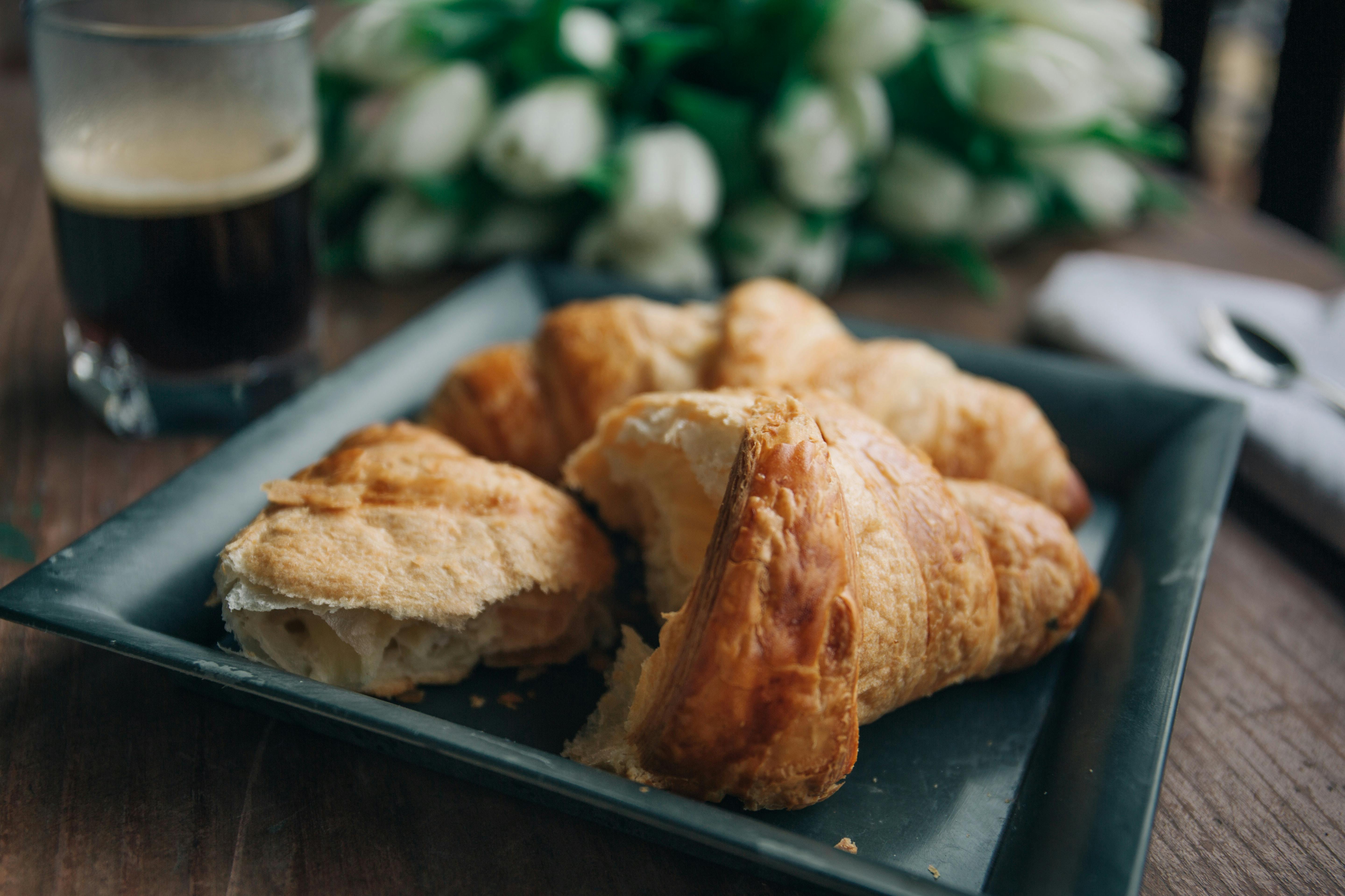 Scones em um prato preto, com um copo de cerveja ao fundo.